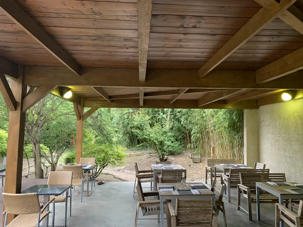 La terrasse couverte du Sushikai, tables en bois ouvertes sur le jardin et les bambous