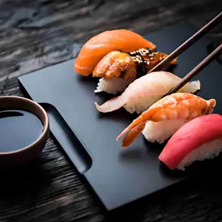 Nigiri sushi au thon, maintenu par des baguettes