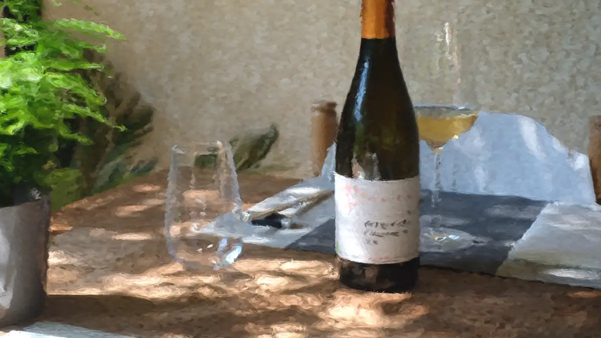 Bouteille de vin blanc de Bourgogne et verres sur une table en terrasse